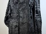 a black coat on a mannequin stand with a white background