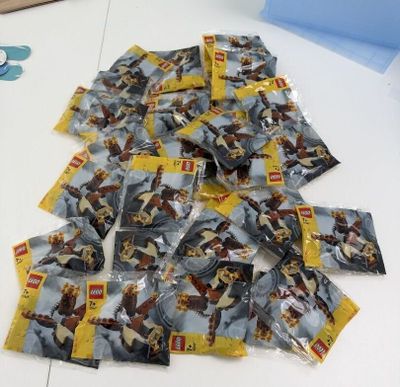 un tas de Lego posé sur une table à côté d'une paire de ciseaux