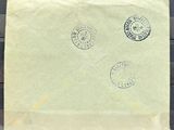 une vieille enveloppe sur laquelle sont collés trois timbres, posée sur une table