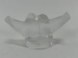 a glass bird that is sitting on top of a glass bowl