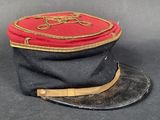 un chapeau noir orné d'un ruban rouge et doré