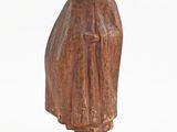 an old wooden statue of a man with a hat and robe