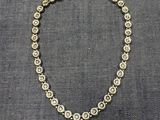 un gros plan d'un collier posé sur un tissu gris
