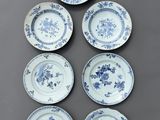 six assiettes bleues et blanches ornées de fleurs, posées sur une table