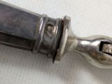 a silver knife with a metal handle on a white surface