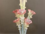 un vase en verre contenant des fleurs roses, posé sur une table