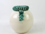 a white vase with a green rope wrapped around it
