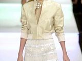 the woman is walking down the runway in a white dress