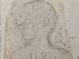 une photo d'une plaque en pierre sur laquelle figure le portrait d'un homme