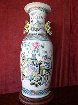 a vase that is sitting on a table in front of a red curtain