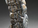 a close up of a statue of two people on a rock