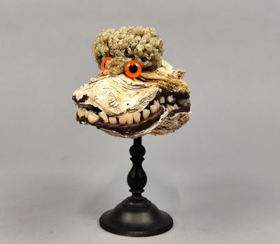 une sculpture représentant un animal en peluche posée sur un socle noir