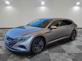 Une voiture argentée est garée sur un sol à damier dans un showroom.
