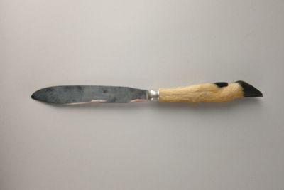 un couteau avec un manche en bois sur une surface blanche