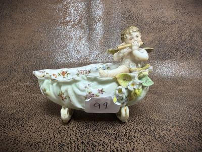 a figurine of a little girl sitting in a bathtub