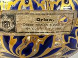a blue and gold bowl with a label on it