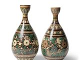 une paire de vases décoratifs posés l'un à côté de l'autre sur une surface blanche