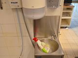 a sink with a toothbrush and a toothpaste dispenser attached to it