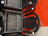 four chairs that are stacked up against a red wall