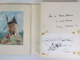 an open book with a drawing of a windmill and a drawing of people