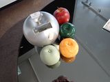 des pommes, des oranges et d'autres fruits sont posés sur une table en verre