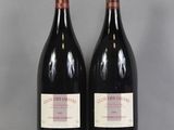 two bottles of red wine sitting next to each other on a table