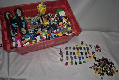 a red box full of legos on a white sheet
