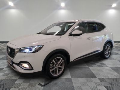 le 4x4 blanc est garé dans une grande pièce au sol en damier