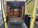 the back of a yellow van with its door open in a parking lot