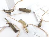 un tas de vieux objets en laiton posés sur une table blanche
