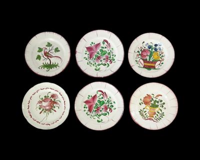 six assiettes ornées de motifs d'oiseaux et de fleurs sur fond noir