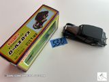 une petite voiture miniature posée sur une table à côté d'une boîte