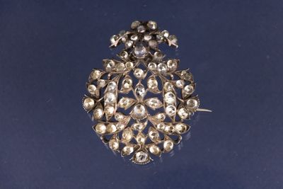 une broche ancienne en argent ornée de perles sur fond bleu