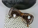 pair of brown sunglasses and a black case on a white table