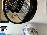 a mirror hanging on the wall above a shelf of cleaning products