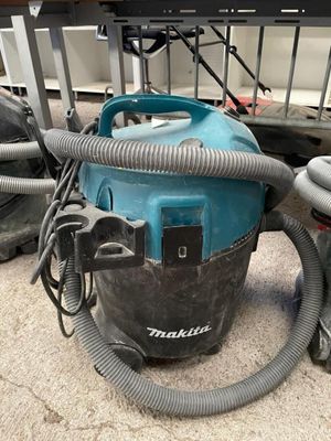 un aspirateur posé par terre à côté d'autres aspirateurs
