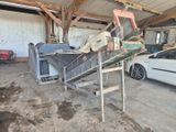 une voiture garée dans un garage, à côté d'un tas de vieilleries