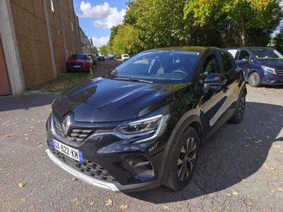 une voiture noire garée sur le bord de la route, devant un immeuble