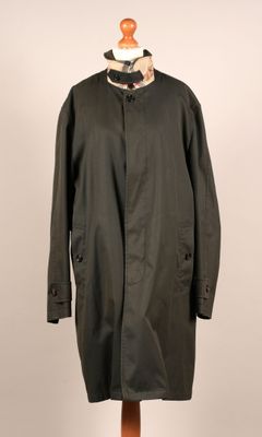 une image d'un manteau noir sur un support de mannequin