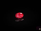 a close up of a red diamond on a black surface