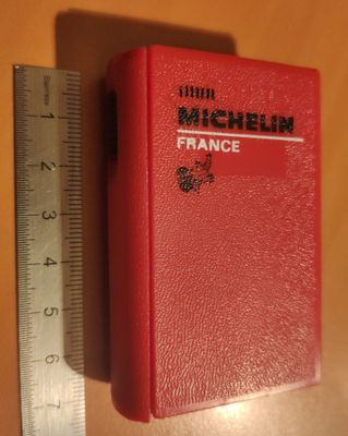 un livre rouge posé à côté d'une règle sur une table