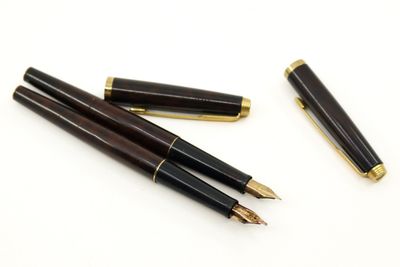 trois types différents de stylos à plume posés sur une surface blanche