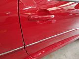 a close up of a red car door handle on the side of the car