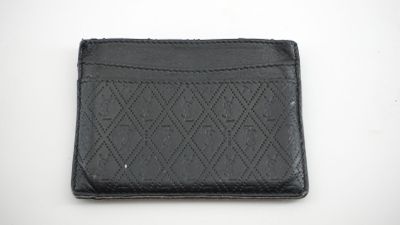 un portefeuille en cuir noir posé sur une table blanche