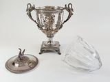 a silver cup and a glass on a table