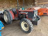 a red tractor that is parked in a garage