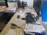 a desk with a computer and a lot of papers on it