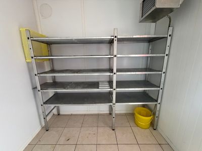une étagère métallique dans le coin d'une pièce