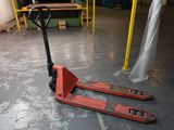a red forklift sitting on the floor in a warehouse
