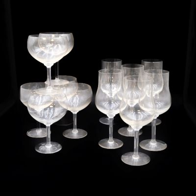 Plusieurs verres à vin transparents sont alignés sur une surface noire